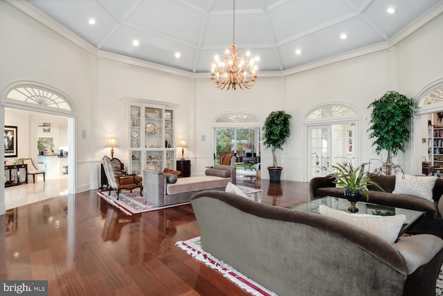 living room featuring recessed lighting, a high ceiling, an inviting chandelier, and wood finished floors