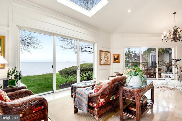 interior space with a water view, high vaulted ceiling, a skylight, a decorative wall, and a chandelier