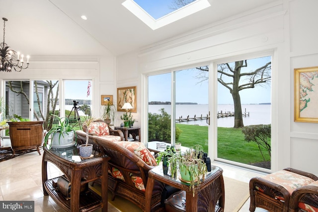 sunroom featuring vaulted ceiling with skylight, a chandelier, and a water view