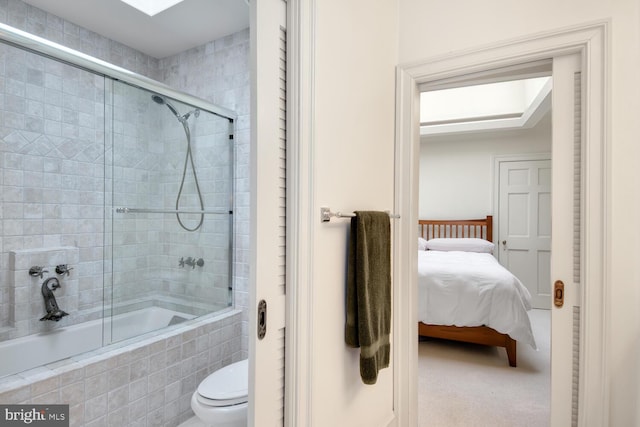 full bathroom featuring tiled shower / bath combo, connected bathroom, and toilet