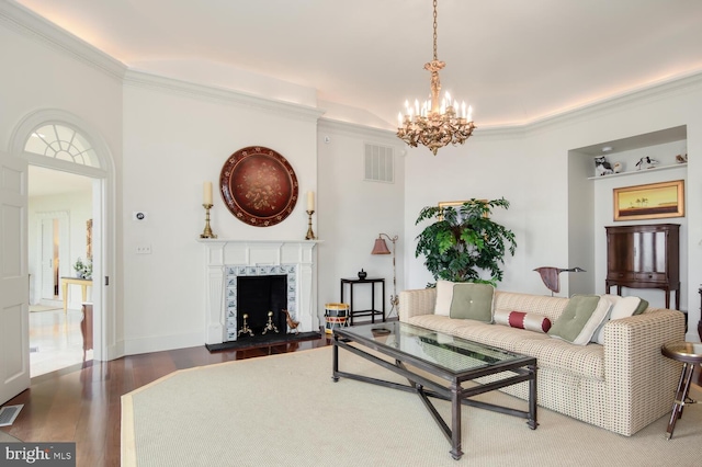 living area featuring a fireplace, wood finished floors, visible vents, and ornamental molding