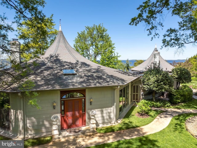 view of front of house featuring a chimney and a shingled roof