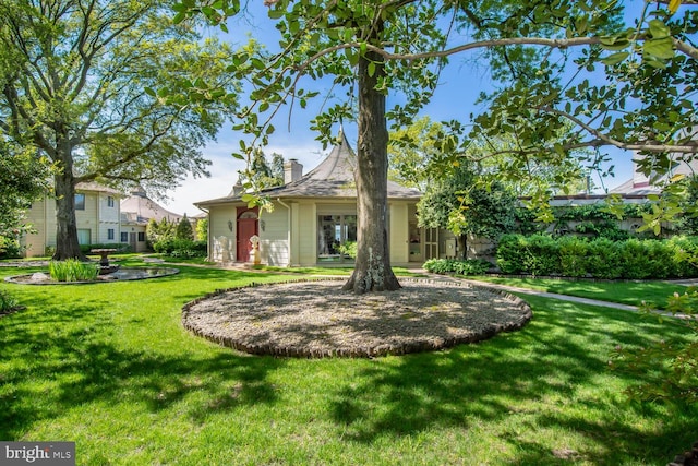 rear view of house with a lawn and a chimney