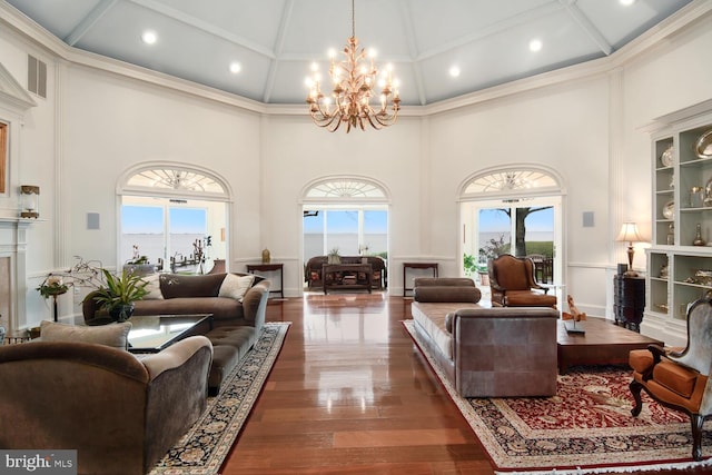 living area featuring recessed lighting, a notable chandelier, wood finished floors, and a towering ceiling