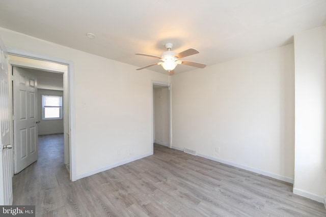 spare room with ceiling fan and light wood-type flooring