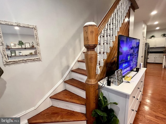 staircase with hardwood / wood-style flooring