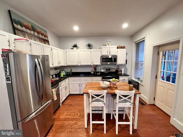 kitchen featuring a breakfast bar area, a kitchen island, appliances with stainless steel finishes, and white cabinetry