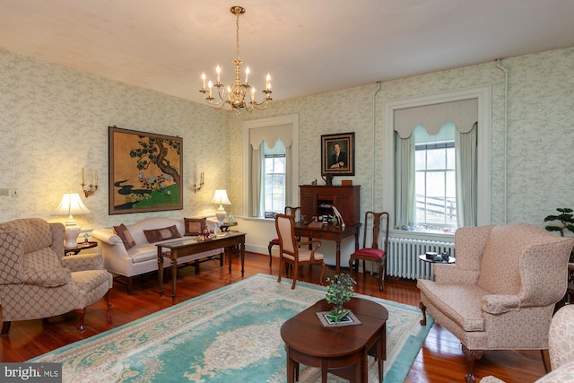 living room with a notable chandelier, wood-type flooring, and radiator