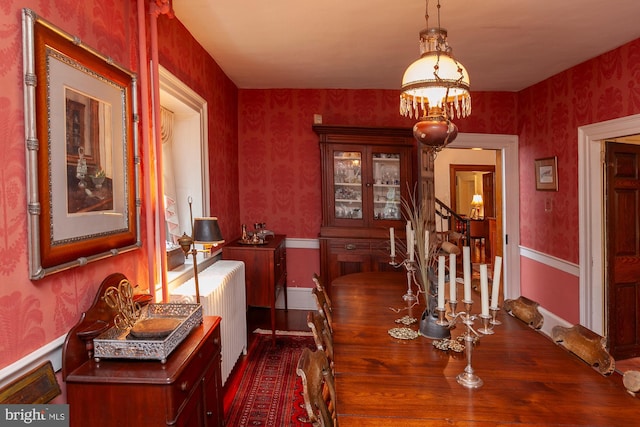 dining space with radiator and a chandelier