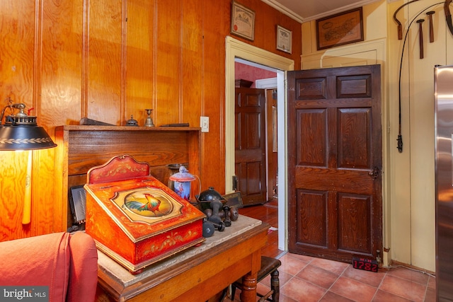 interior space with light tile patterned flooring, crown molding, and wooden walls