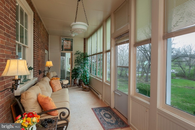 sunroom / solarium with a baseboard radiator, a wealth of natural light, and ceiling fan