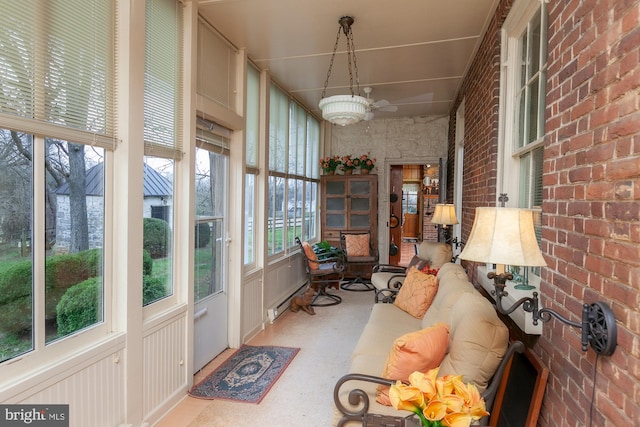 sunroom / solarium with baseboard heating and ceiling fan