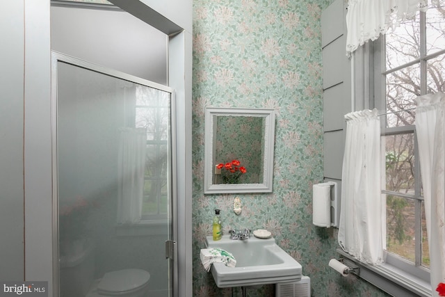 bathroom with sink and a shower with door