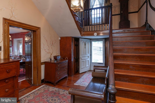 stairway featuring wood-type flooring and vaulted ceiling