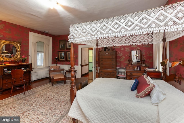 bedroom featuring hardwood / wood-style floors and radiator heating unit