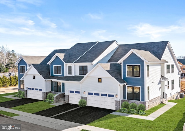 view of front of home featuring a garage, cooling unit, and a front lawn