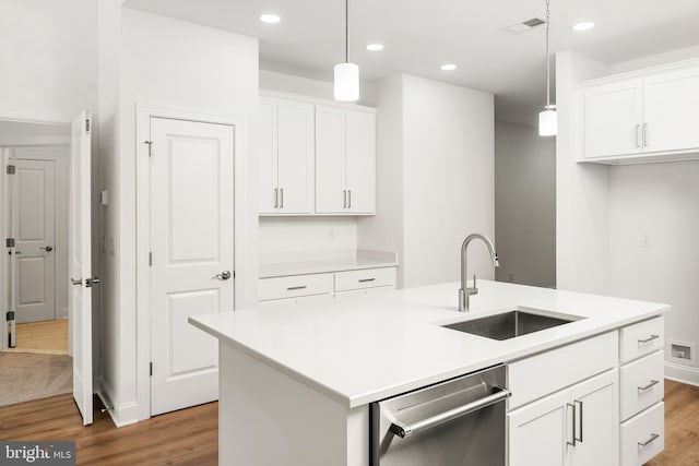 kitchen with an island with sink, hanging light fixtures, sink, hardwood / wood-style flooring, and dishwasher