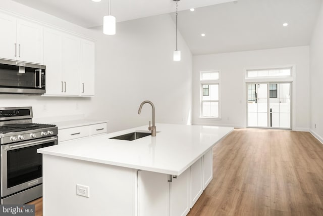 kitchen with pendant lighting, an island with sink, appliances with stainless steel finishes, and sink