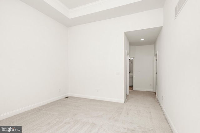 empty room with ornamental molding and light colored carpet