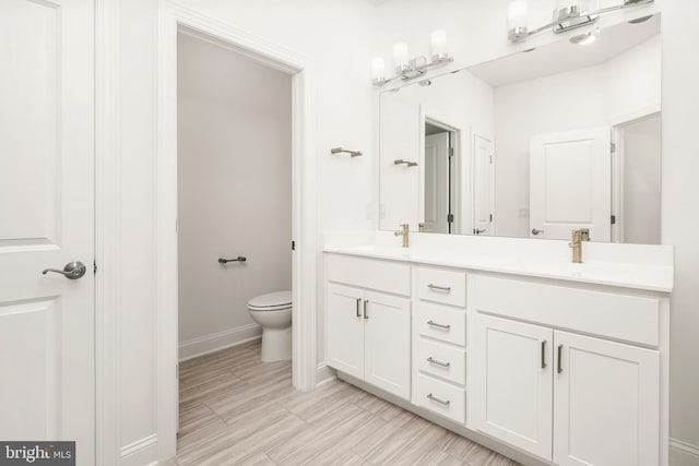 bathroom featuring hardwood / wood-style flooring, vanity, and toilet