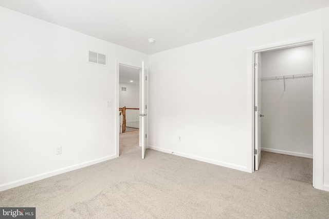 unfurnished bedroom featuring a closet and light colored carpet