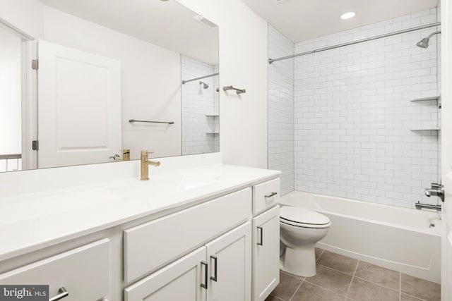 full bathroom with tile patterned flooring, tiled shower / bath, vanity, and toilet