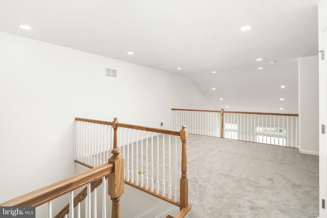 hallway featuring lofted ceiling and carpet floors