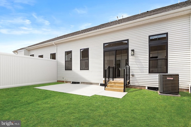 rear view of house featuring a lawn, central AC unit, and a patio area