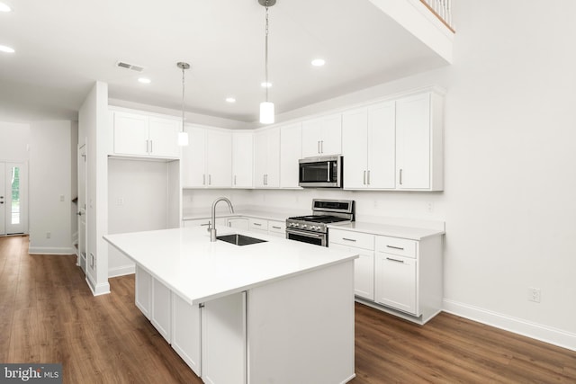 kitchen with a kitchen island with sink, sink, stainless steel appliances, dark hardwood / wood-style floors, and white cabinets