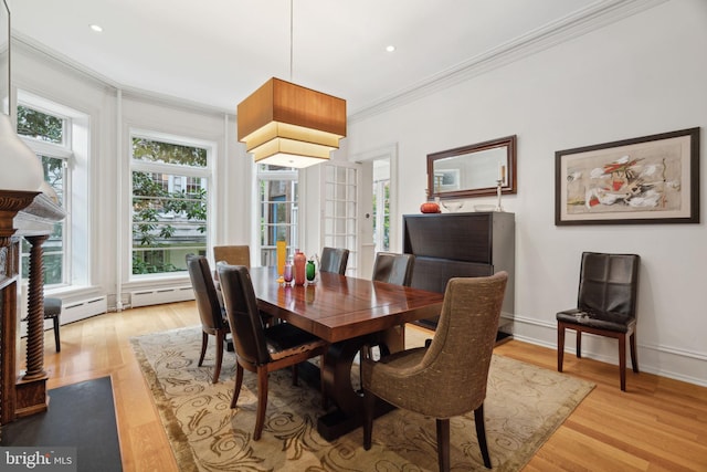 dining room featuring light hardwood / wood-style flooring, a fireplace, and ornamental molding