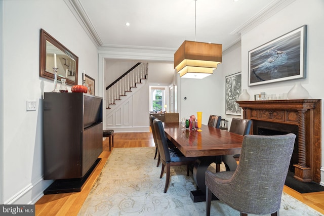 dining room with light hardwood / wood-style flooring and ornamental molding