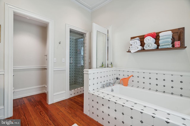 bathroom with crown molding, hardwood / wood-style flooring, and shower with separate bathtub