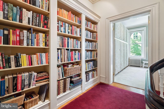 sitting room with ornamental molding, radiator, and carpet floors