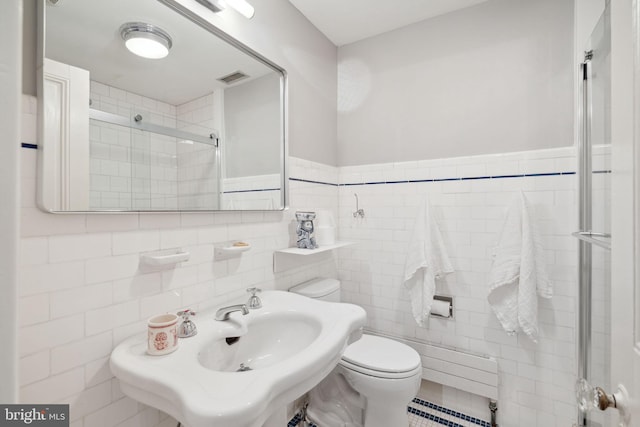 bathroom featuring sink, tile walls, toilet, and a baseboard radiator