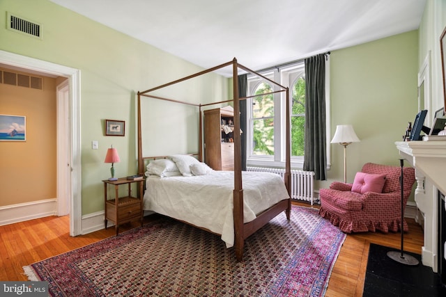 bedroom featuring hardwood / wood-style flooring and radiator