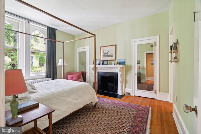 bedroom featuring hardwood / wood-style floors and radiator heating unit