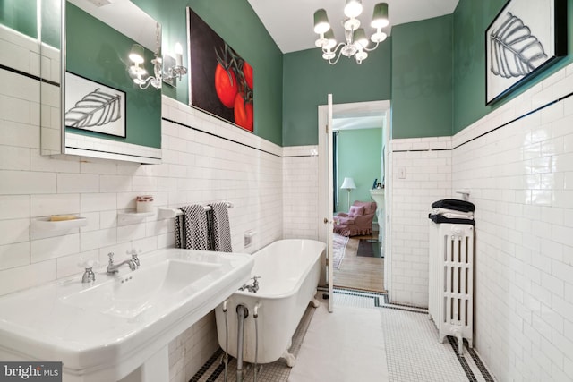 bathroom featuring tile walls, a tub, tile flooring, a notable chandelier, and radiator heating unit