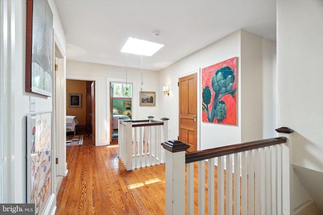 corridor featuring hardwood / wood-style flooring and a skylight