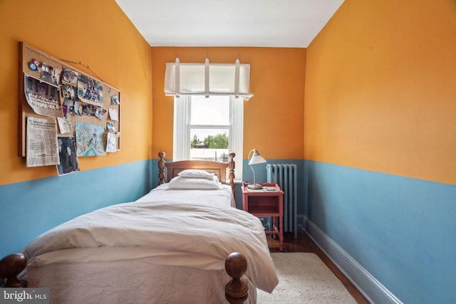 bedroom with wood-type flooring and radiator heating unit