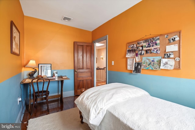 bedroom with dark hardwood / wood-style floors