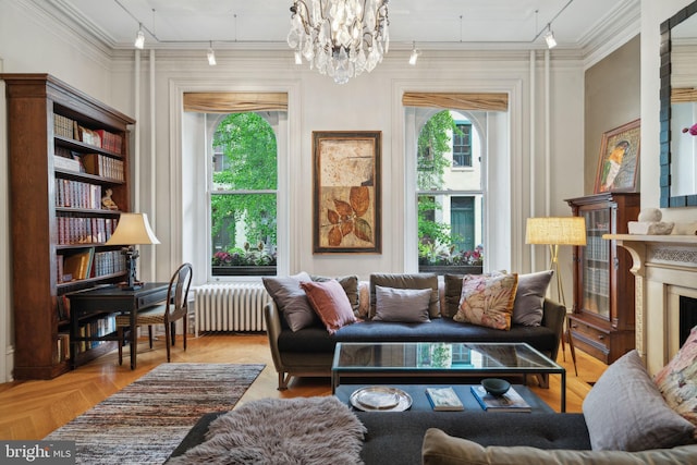 living room with a notable chandelier, parquet flooring, radiator, ornamental molding, and track lighting