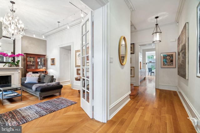 hallway featuring ornamental molding, a notable chandelier, and light parquet floors