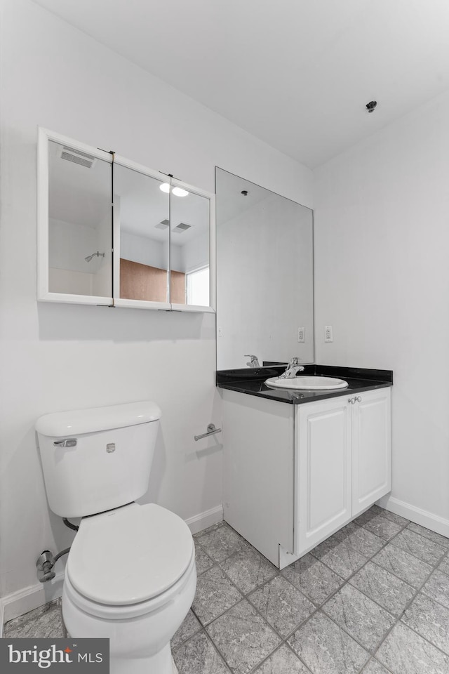 bathroom with tile floors, toilet, and vanity