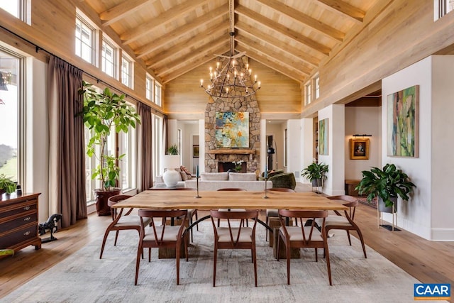 dining area with beamed ceiling, high vaulted ceiling, a notable chandelier, light wood-type flooring, and wooden ceiling