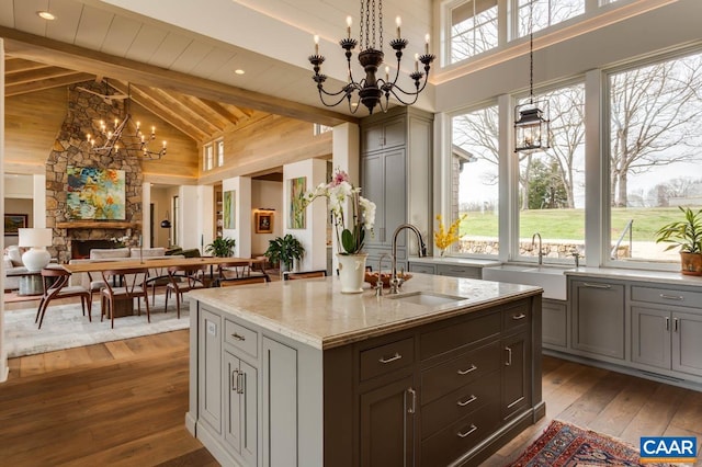 kitchen featuring beam ceiling, pendant lighting, dark hardwood / wood-style floors, and an inviting chandelier