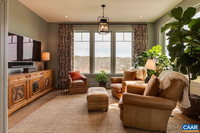 living room featuring light hardwood / wood-style flooring, a wealth of natural light, and a chandelier