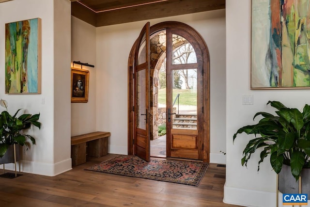 foyer entrance with beamed ceiling and dark hardwood / wood-style floors