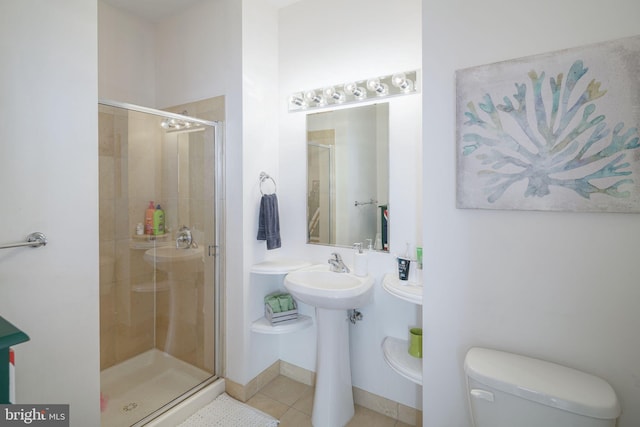 bathroom featuring tile patterned flooring, toilet, and walk in shower