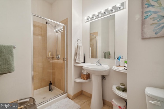 bathroom featuring tile patterned flooring, toilet, an enclosed shower, and sink