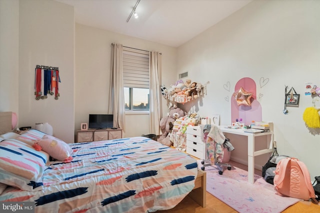 bedroom featuring light wood-type flooring and rail lighting